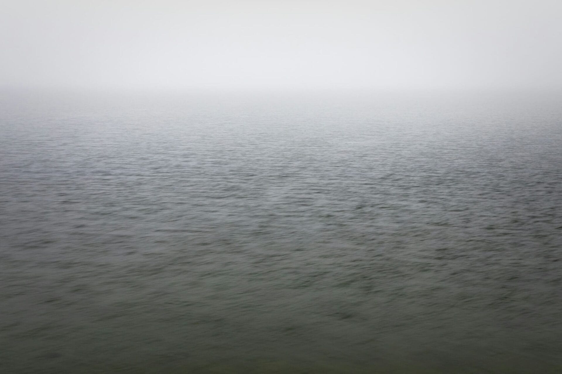 Graue Wasserfläche im Nebel als Bild für Trauer bei Krebs.