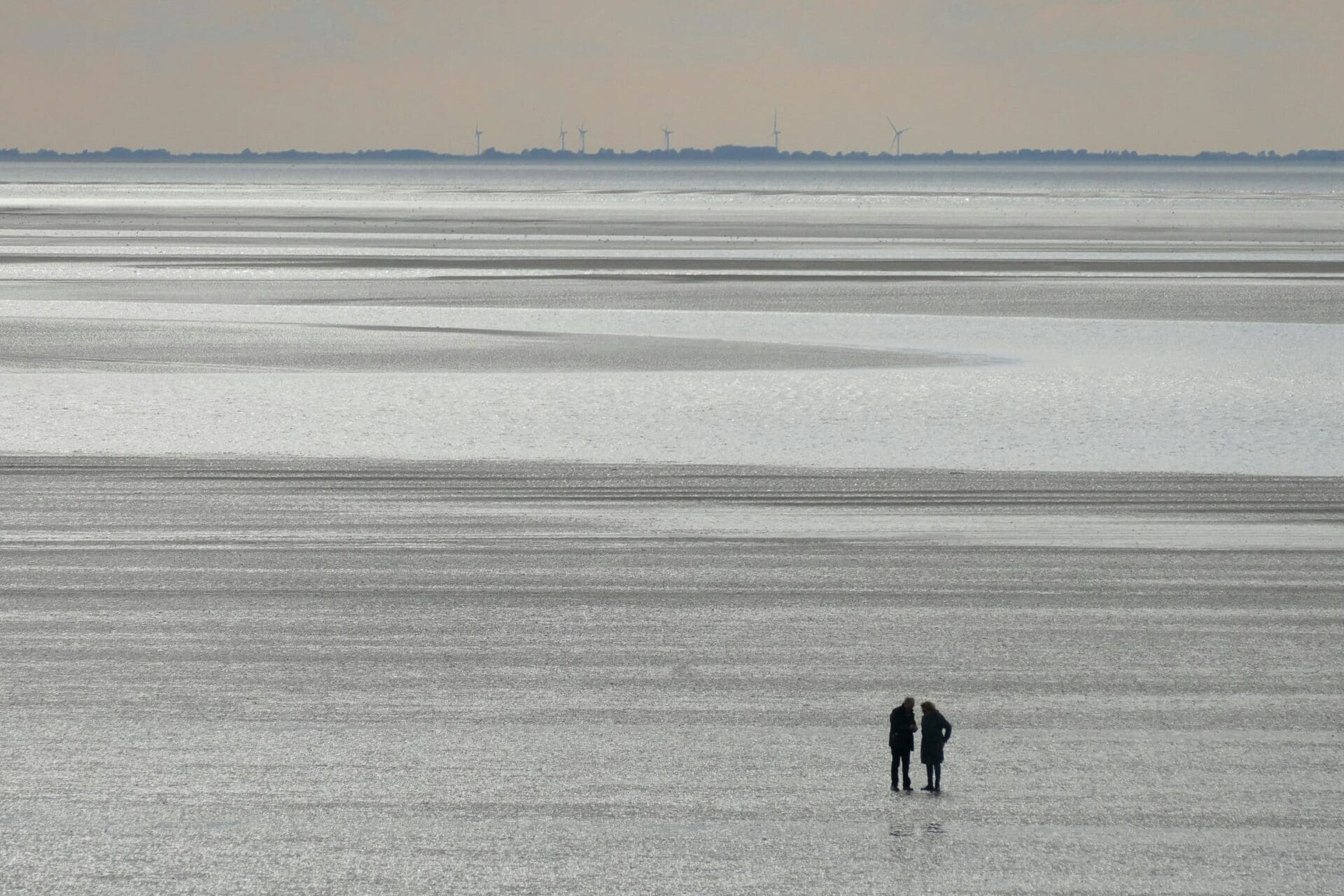 Zwei Menschen stehen zusammen im Wattenmeer – Sinnbild für Nähe und Rückzug bei Krebs